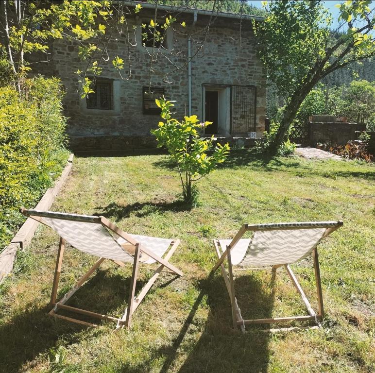 deux chaises assises dans l'herbe devant un bâtiment dans l'établissement Casa tradicional en Orozko, à Murueta-Orozko