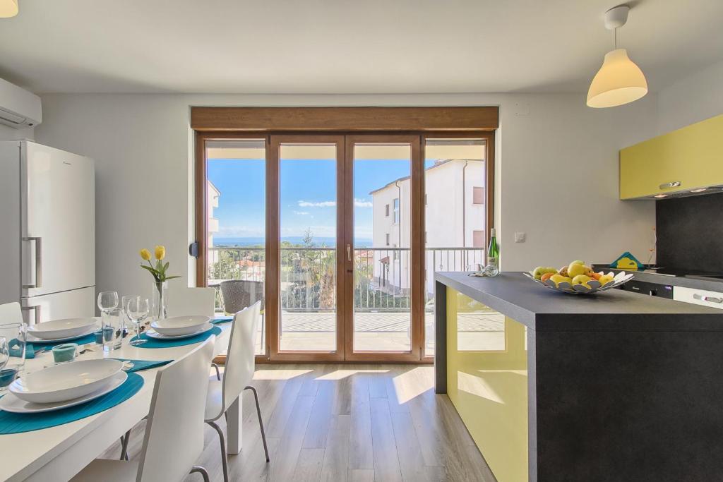 a kitchen with a table and chairs with a view at Apartments Spagnolo in Ližnjan