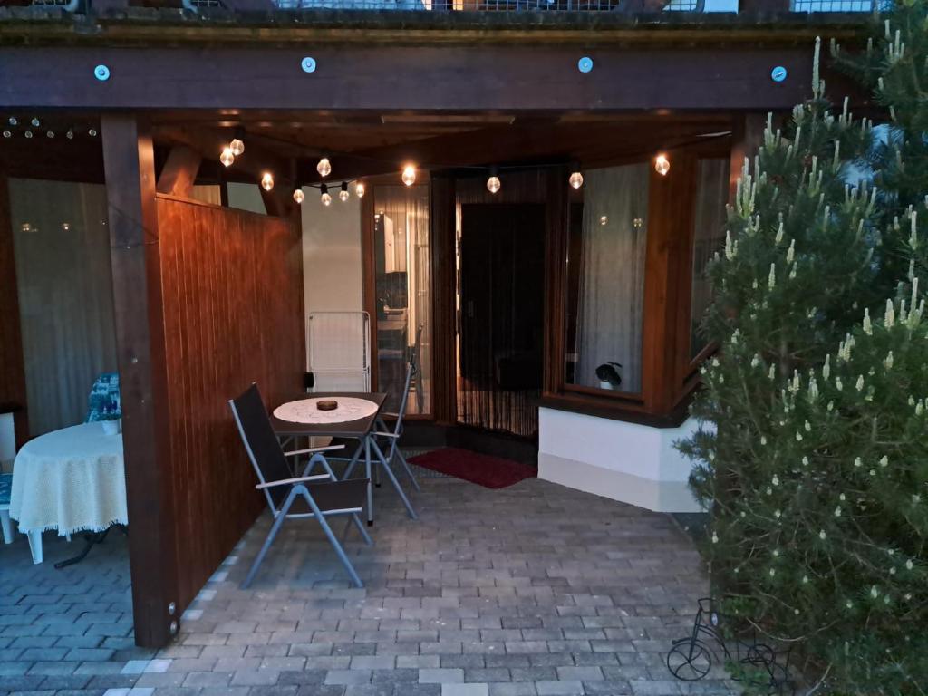 patio ze stołem i krzesłami oraz choinką świąteczną w obiekcie Viktor Apartment w mieście Titisee-Neustadt