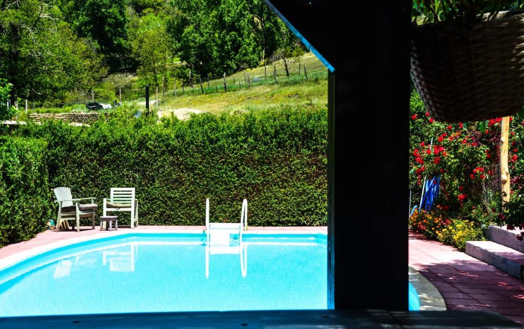 a swimming pool with two chairs and a table at Los Castaños, Vivienda Rural, Capileira in Capileira