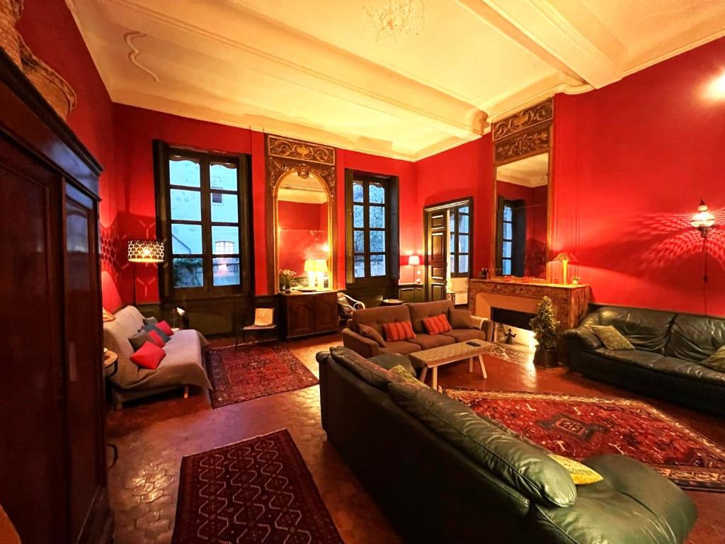 アヴィニョンにあるPalais des Papes - Spacious Historic Apartment in Private Mansion ! Free PARKING Nearby ! Spacieux Appartement Historique dans Hôtel Particulier ! PARKING à proximité Offert !の赤い壁のリビングルーム(ソファ、ピアノ付)