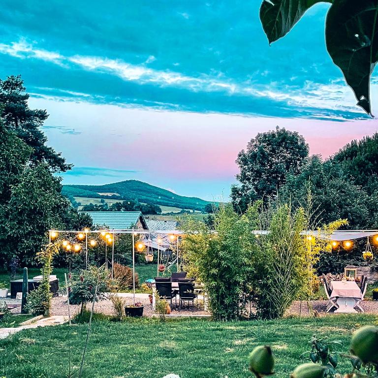 une vue d'un jardin au crépuscule avec des lumières dans l'établissement Silent Valley Bed & Breakfast, à Larochemillay