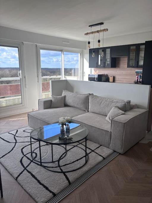 a living room with a couch and a table at Appartement T2 en résidence privée in Maurepas