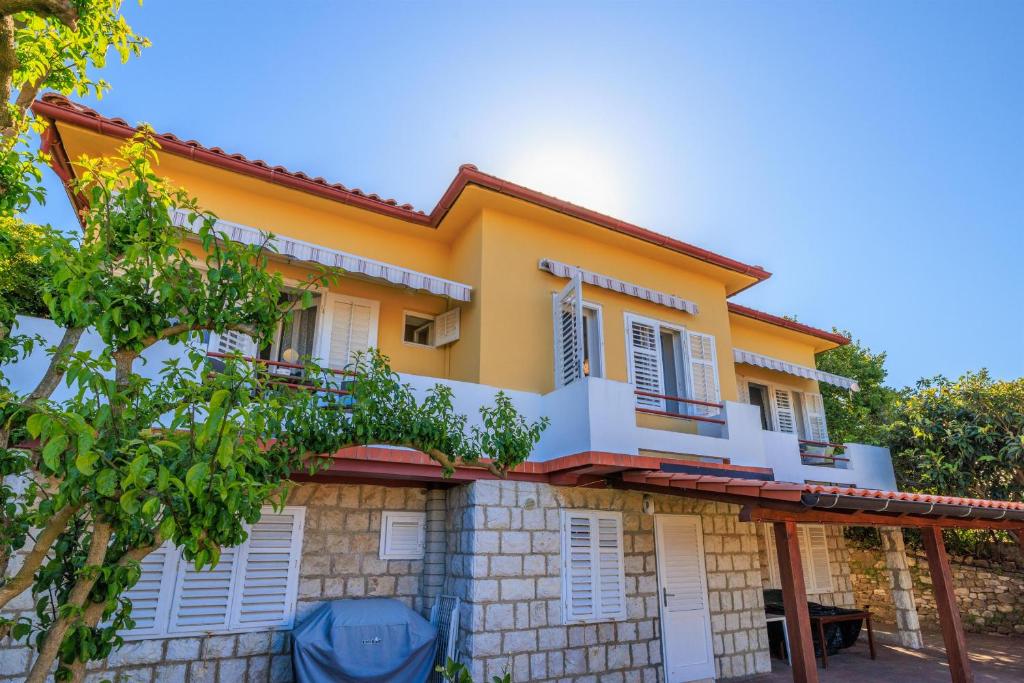 a house with a lot of windows at Apartment Villa Strenja in Rab