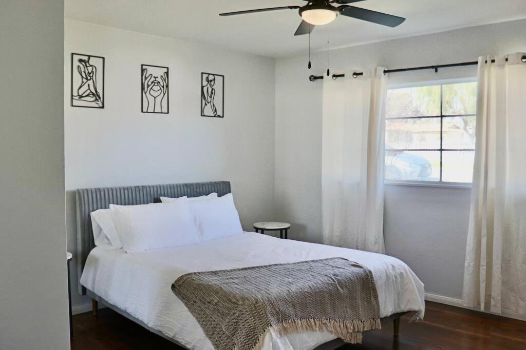 Un dormitorio con una cama con ventilador de techo. en Modern La Cresta, en Bakersfield
