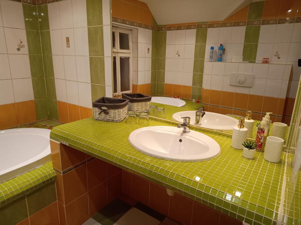 a bathroom with two sinks and a green tiled counter at Ubytování Háj in Jindřichovice