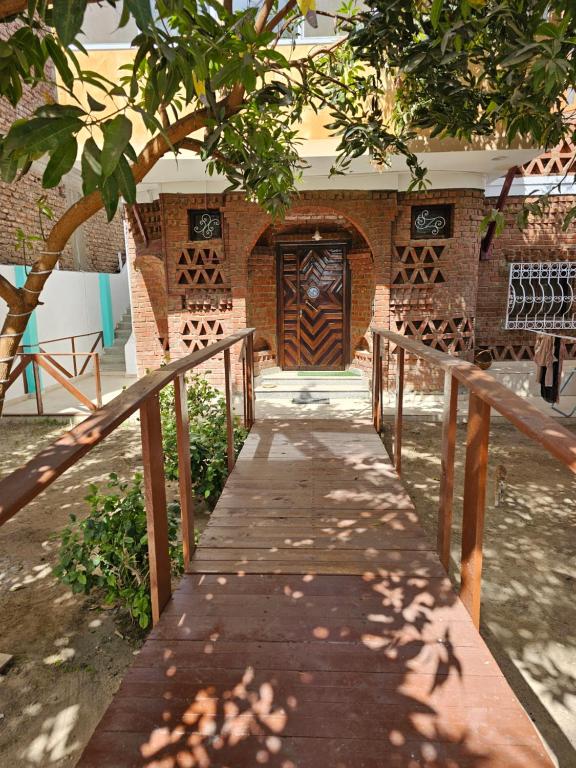 una pasarela de madera que conduce a la puerta de un edificio en Casa Helvetica, en Luxor