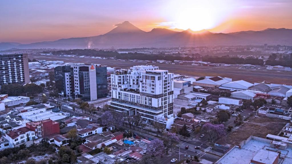 una vista aerea di una città con una montagna sullo sfondo di APARTAMENTO CON TERRAZA CERCA DEL AEROPUERTO a Guatemala