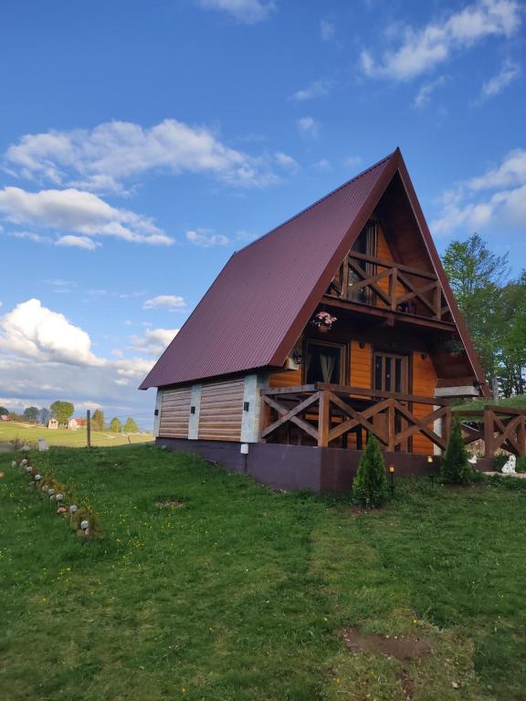 a large wooden barn with a gambrel roof at Mountain house Drveni Raj in Žabljak