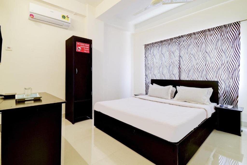 a bedroom with a bed with a black and white headboard at OYO Home Cozy Home in Guwahati