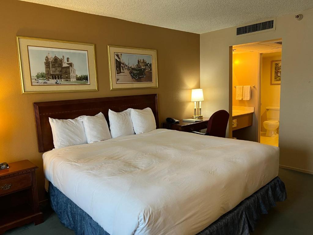una habitación de hotel con una gran cama blanca. en Hardman House, en Carson City