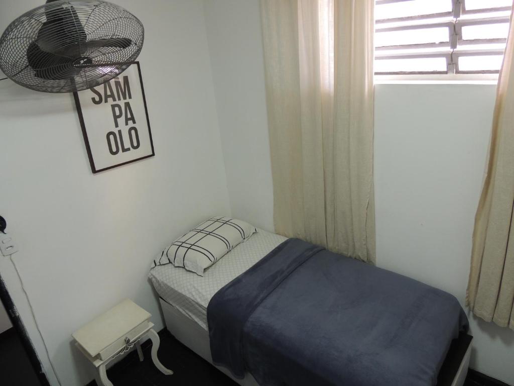 a small bedroom with a bed and a fan at room itaim in Sao Paulo