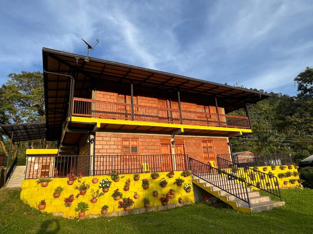 a building with a balcony and a bunch of flowers at HOTEL EMBRUJO CAMPESTRE in Jardin