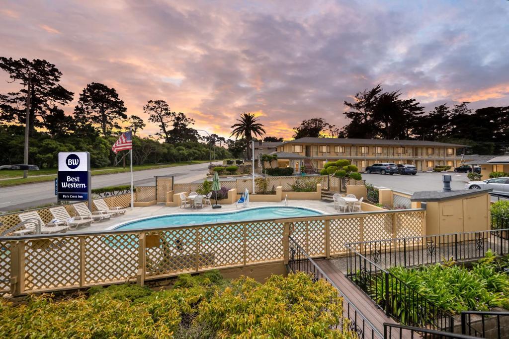 a view of a resort with a pool and chairs at Best Western Park Crest Inn in Monterey