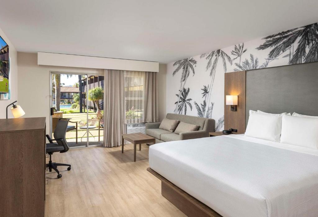 Habitación de hotel con cama y sala de estar. en Best Western Plus Pepper Tree Inn en Santa Bárbara