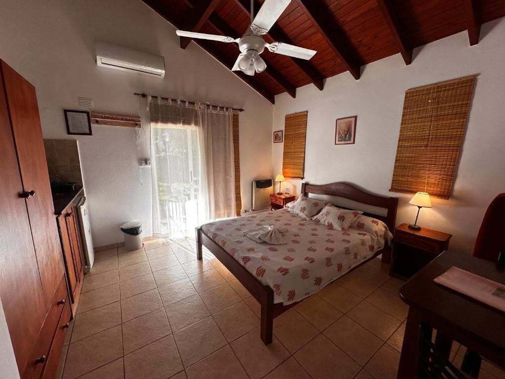 een slaapkamer met een bed en een plafondventilator bij Luna Azul in Merlo
