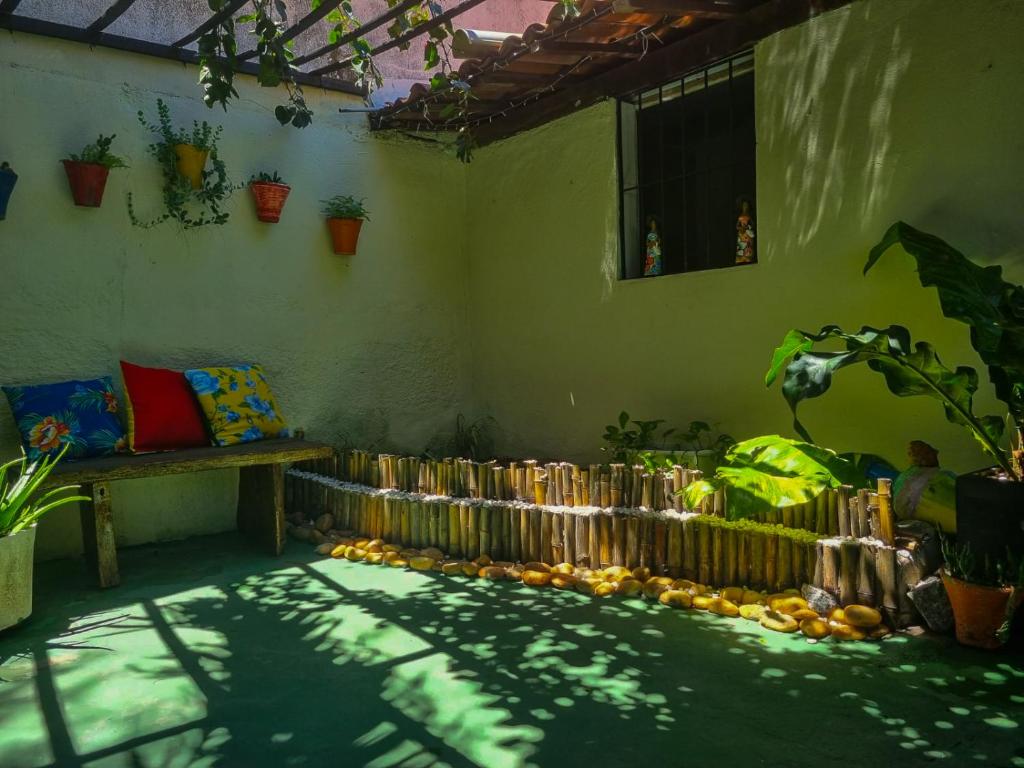 una stanza con tavolo, panca e piante di Pousada Residencial Porto de Galinhas a Porto De Galinhas