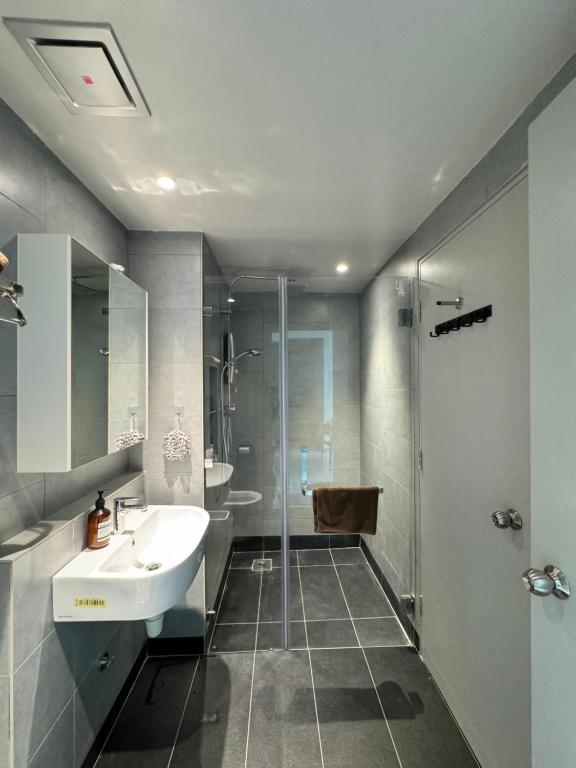 un baño con lavabo y ducha en Jesselton Quay l Family Suite l Deluxe l Sunset Seaview l 2R1B l 5 pax, en Kota Kinabalu