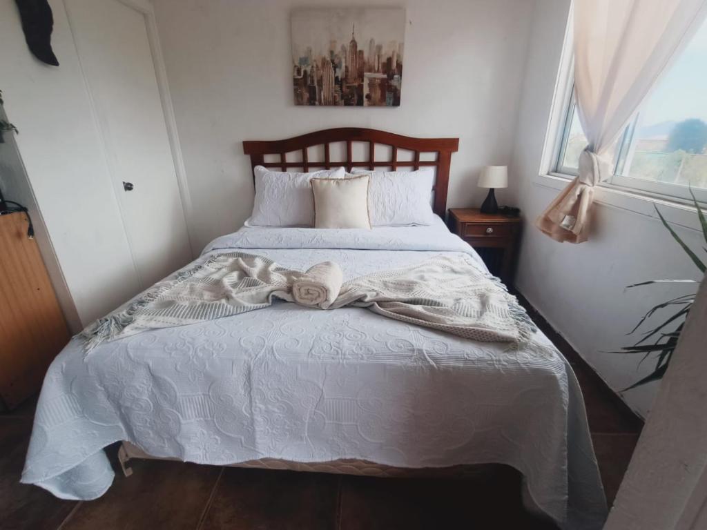 a bedroom with a bed with a white comforter at Cabañas Toto Península Beach in Totoralillo