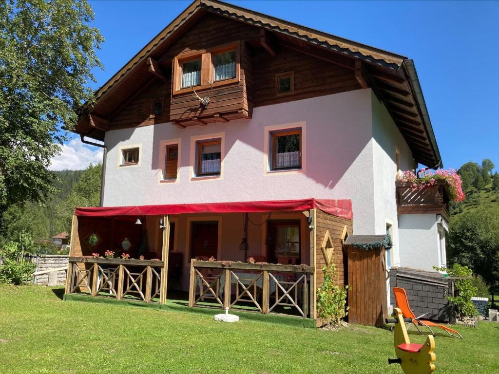 uma casa com um toldo vermelho no quintal em Zonnen-Alp em Forstau