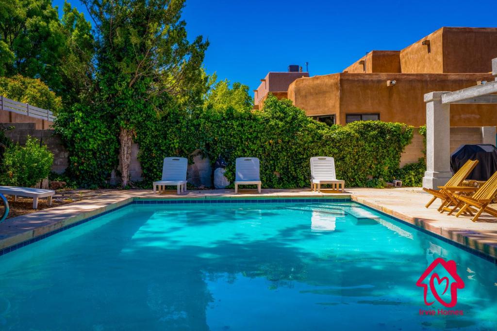 uma piscina com duas cadeiras num quintal em Pueblo Moon w Pool - An Irvie Home em Alameda