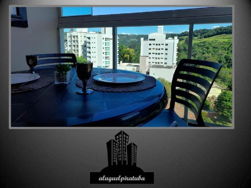 a blue table and chairs with a view of a city at Apto climatizado 502, apenas 5 min das Thermas in Piratuba
