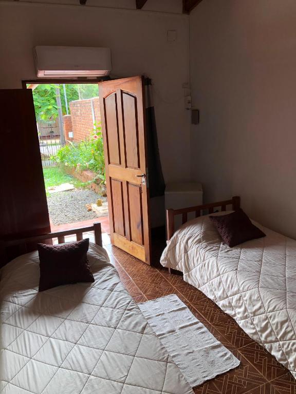 2 camas en una habitación con puerta y ventana en Alquiler por día zona ideal Posadas, Misiones en Posadas