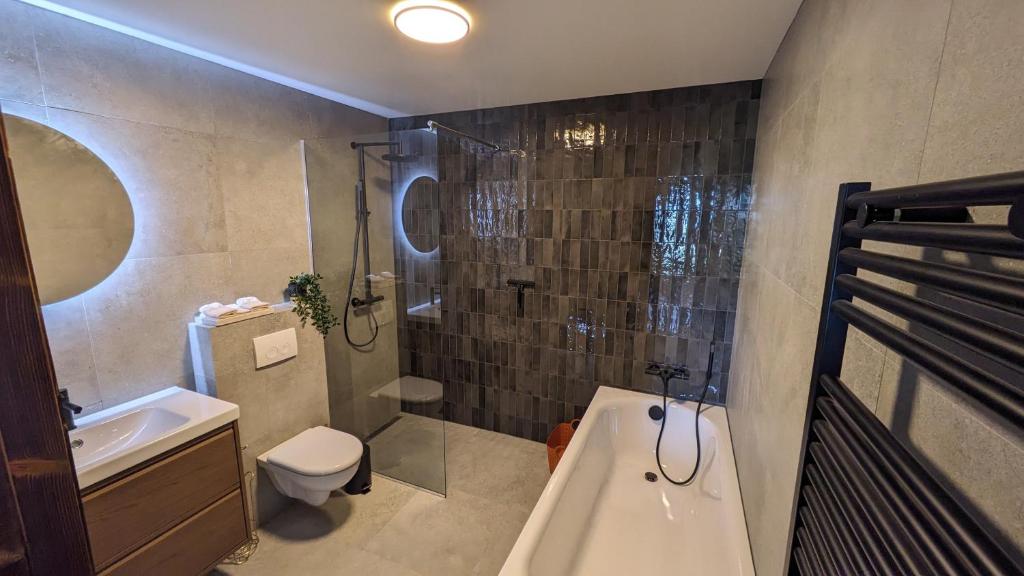 a bathroom with a toilet and a shower and a sink at Black Beach Apartment - Vík in Vík