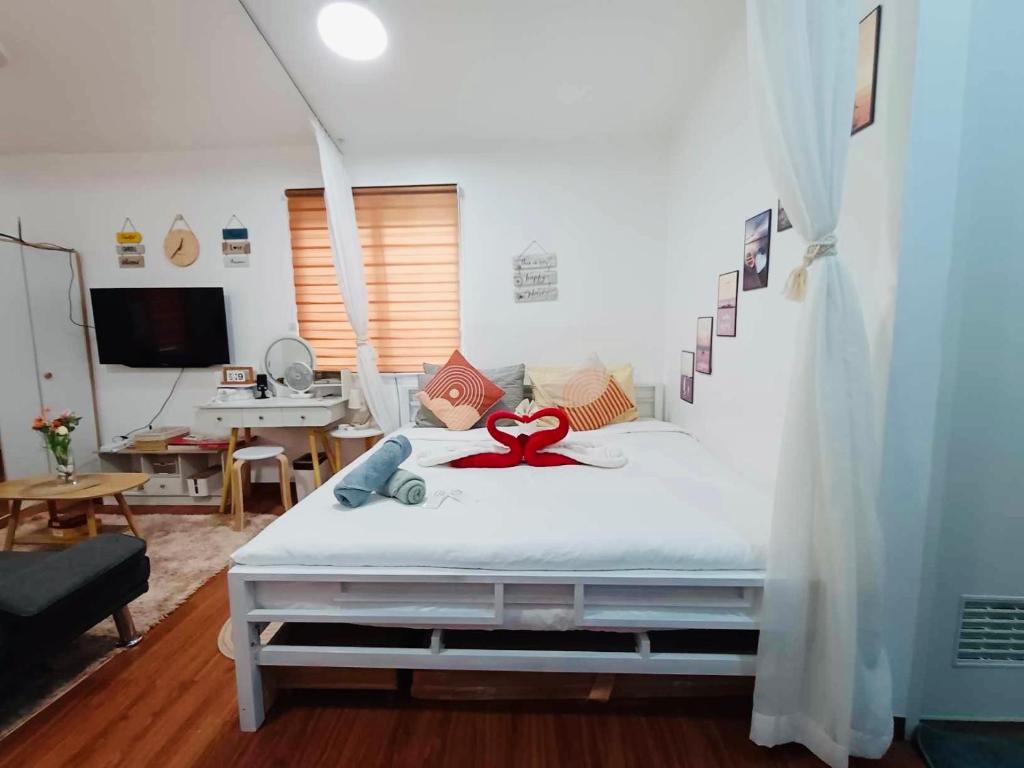 Un dormitorio con una cama con una cinta roja. en S&E-1 Tiny Guest House - Olango Island, en Lapu Lapu City