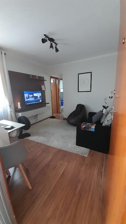 un soggiorno con divano e TV a schermo piatto di Apartamento Viracopos Campinas a Viracopos
