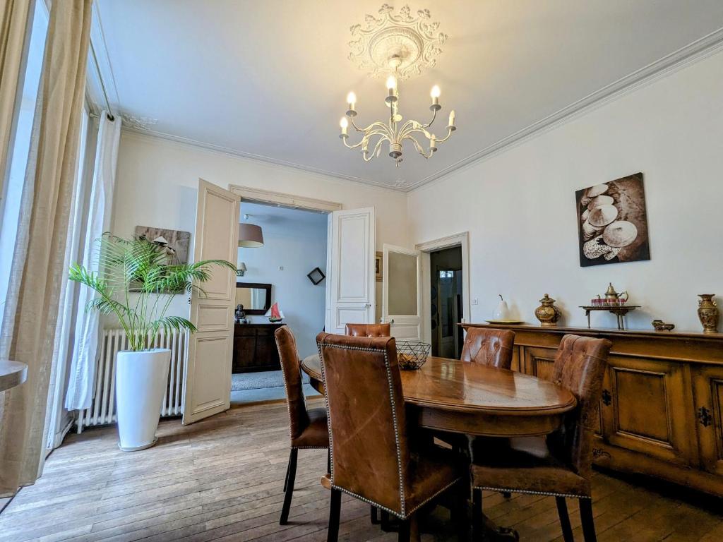 una sala da pranzo con tavolo, sedie e lampadario pendente di Guestroom Châteauroux, 1 pièce, 4 personnes - FR-1-591-388 a Châteauroux