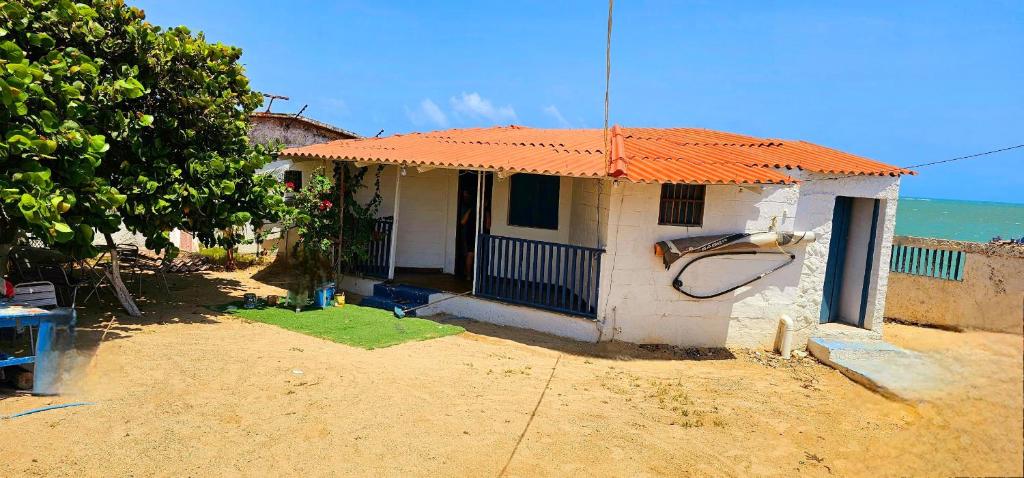 mały biały dom z pomarańczowym dachem w obiekcie Cabaña Adicora w mieście Arícula