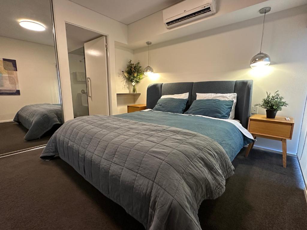 a bedroom with a bed with a blue comforter at The Retreat Adelaide in Adelaide
