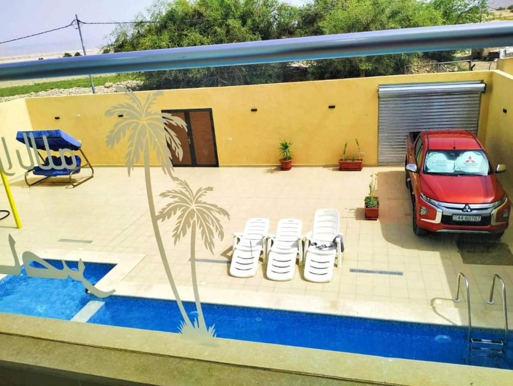 un coche aparcado en un patio junto a una piscina en شاليه سد الموجب, en Al Mara‘ah