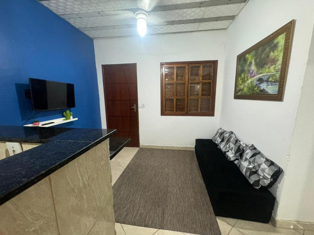Una sala de estar con un sofá y un televisor de pantalla plana. en hospedagemsaopedro apartamento 2, en São Pedro da Aldeia