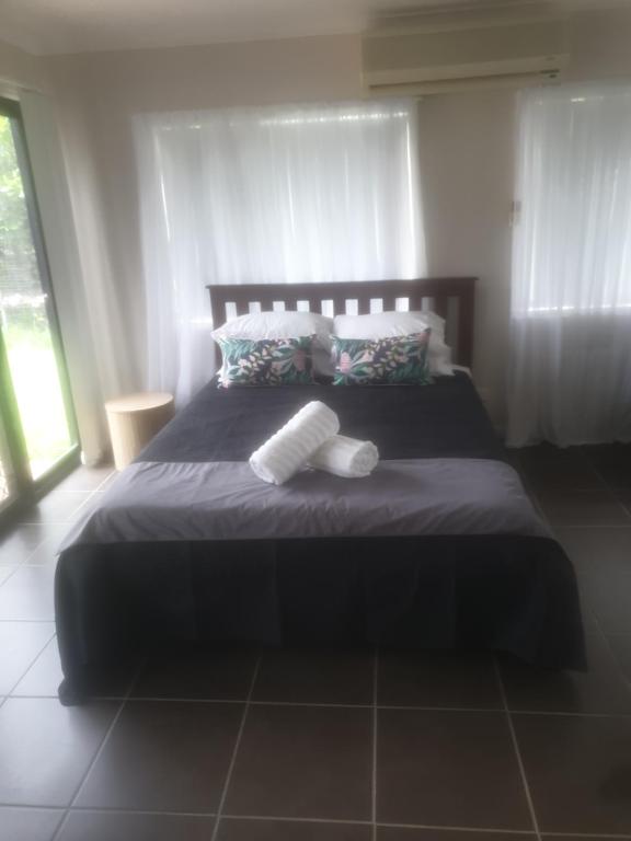 ein Schlafzimmer mit einem Bett mit zwei Handtüchern darauf in der Unterkunft FRANGIPANI HOUSE in Gladstone
