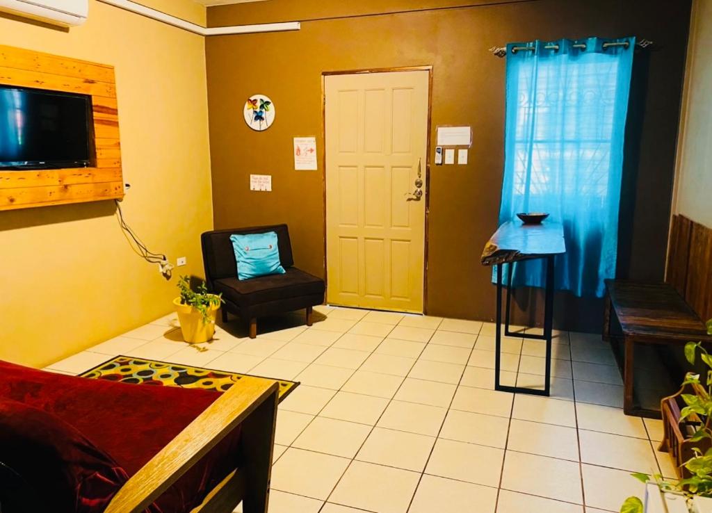 ein Wohnzimmer mit einem Sofa und einem Stuhl in der Unterkunft City Garden 2 Apartment in Belize City