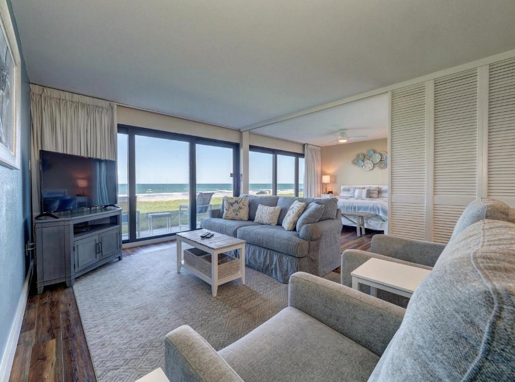 ein Wohnzimmer mit einem Sofa und einem TV in der Unterkunft Island House Condominiums Unit 113 in Padre Island