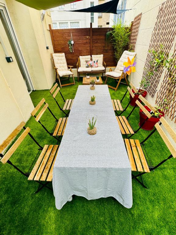 un patio avec une table et des chaises sur l'herbe dans l'établissement LOFT DESIGN DUPLEX 2 CHAMBRES TERRASSE 20M2, à Marseille