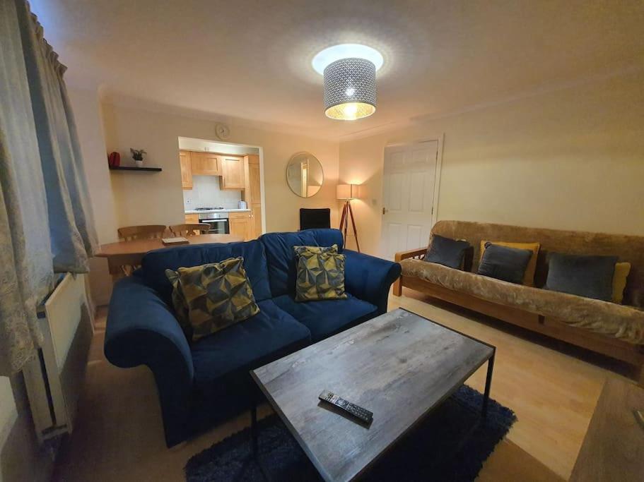 ein Wohnzimmer mit einem blauen Sofa und einem Tisch in der Unterkunft Modern 2BR Chester Flat in Chester