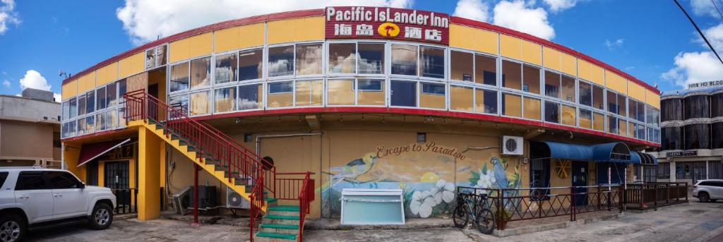 um edifício amarelo e vermelho com um mural em Pacific Islander Inn em Garapan