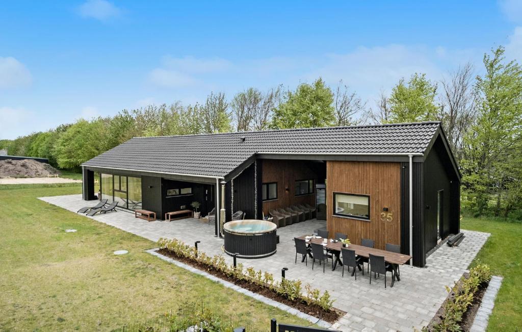 a large black cabin with a table and a hot tub at 4 Bedroom Cozy Home In Hadsund in Hadsund