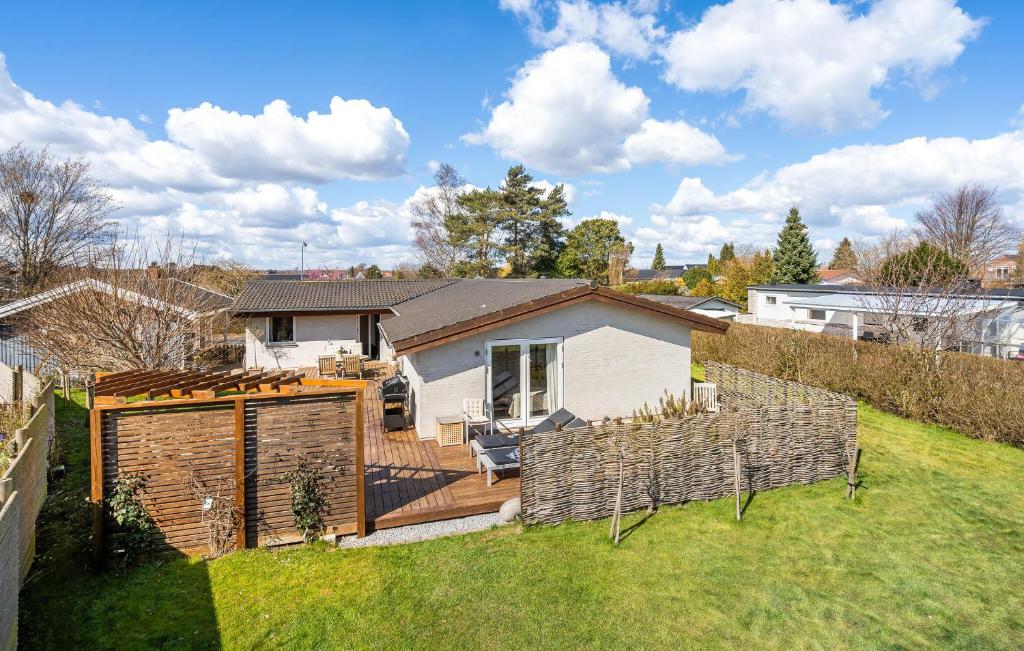 un patio trasero con una terraza de madera y una casa en Amazing Home In Kge With Kitchen, en Køge