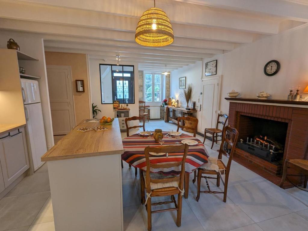a kitchen and dining room with a table and a fireplace at Moulin Authentique avec Jardin Privé et Activités pour Familles et Amis en Bord de Rivière - FR-1-653-251 in Saint-Mary