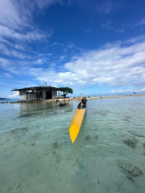 a yellow kayak in the water in front of a building at B&B chez Anouk in Tevaitoa