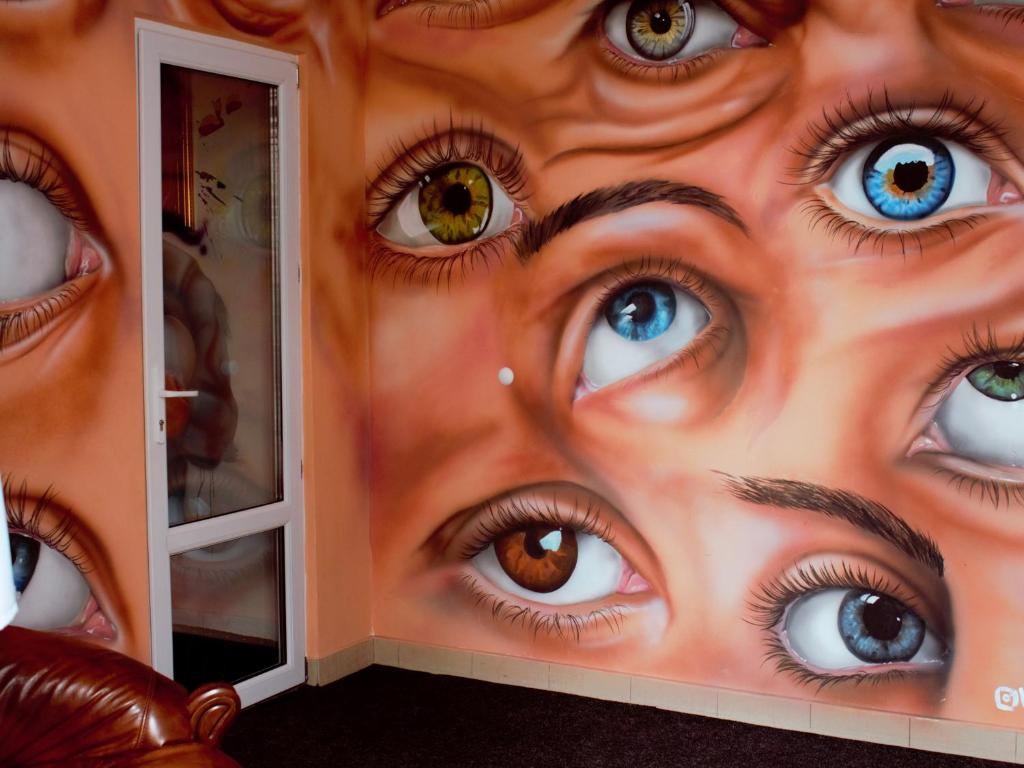une fresque des yeux sur un mur dans l'établissement All Eyes Hostel, à Kamianets-Podilsky