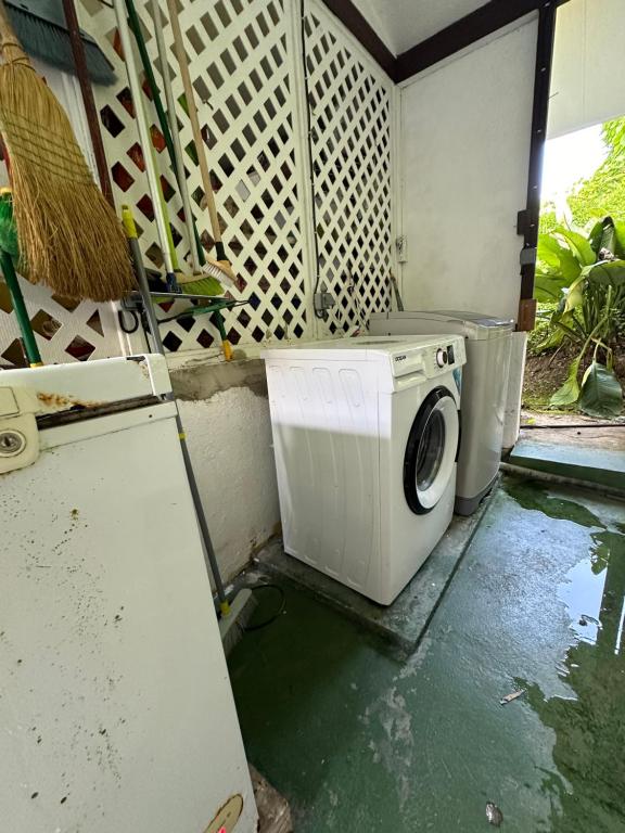 a washing machine in a kitchen with a refrigerator at B&B chez Anouk in Tevaitoa