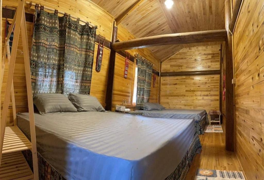 Ce lit se trouve dans un dortoir doté d'un mur en bois. dans l'établissement Homestay Bethel, à Sa Pả