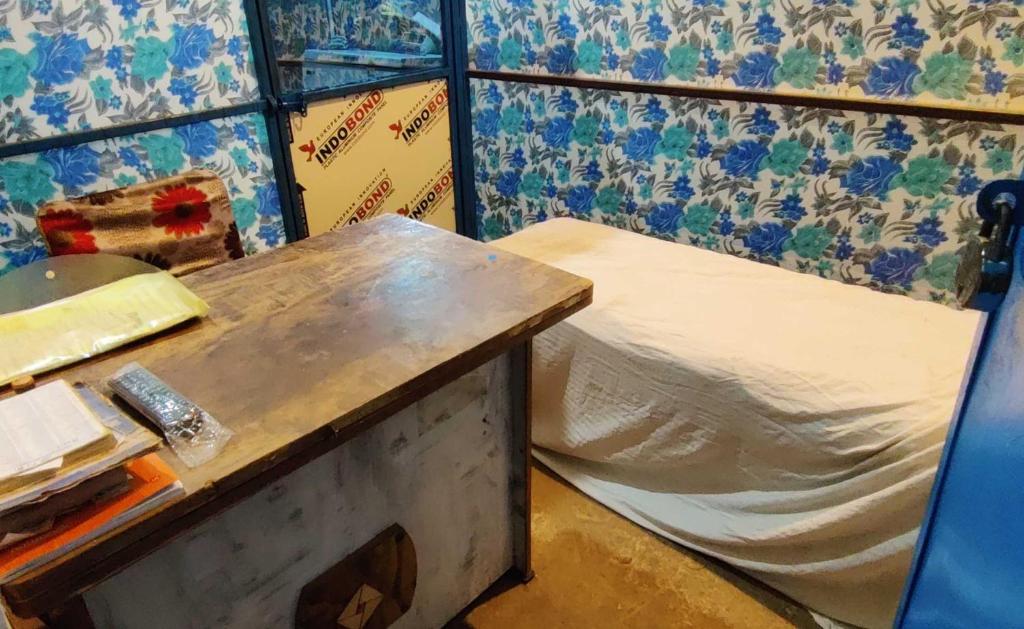 Kleines Zimmer mit einem Bett und einem Tisch in der Unterkunft OYO Gopal Hotel And Family Restaurant in Gwalior