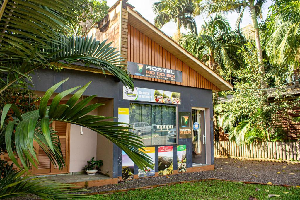 a gas station with a palm tree in front of it at Hostel Rio do Boi in Praia Grande